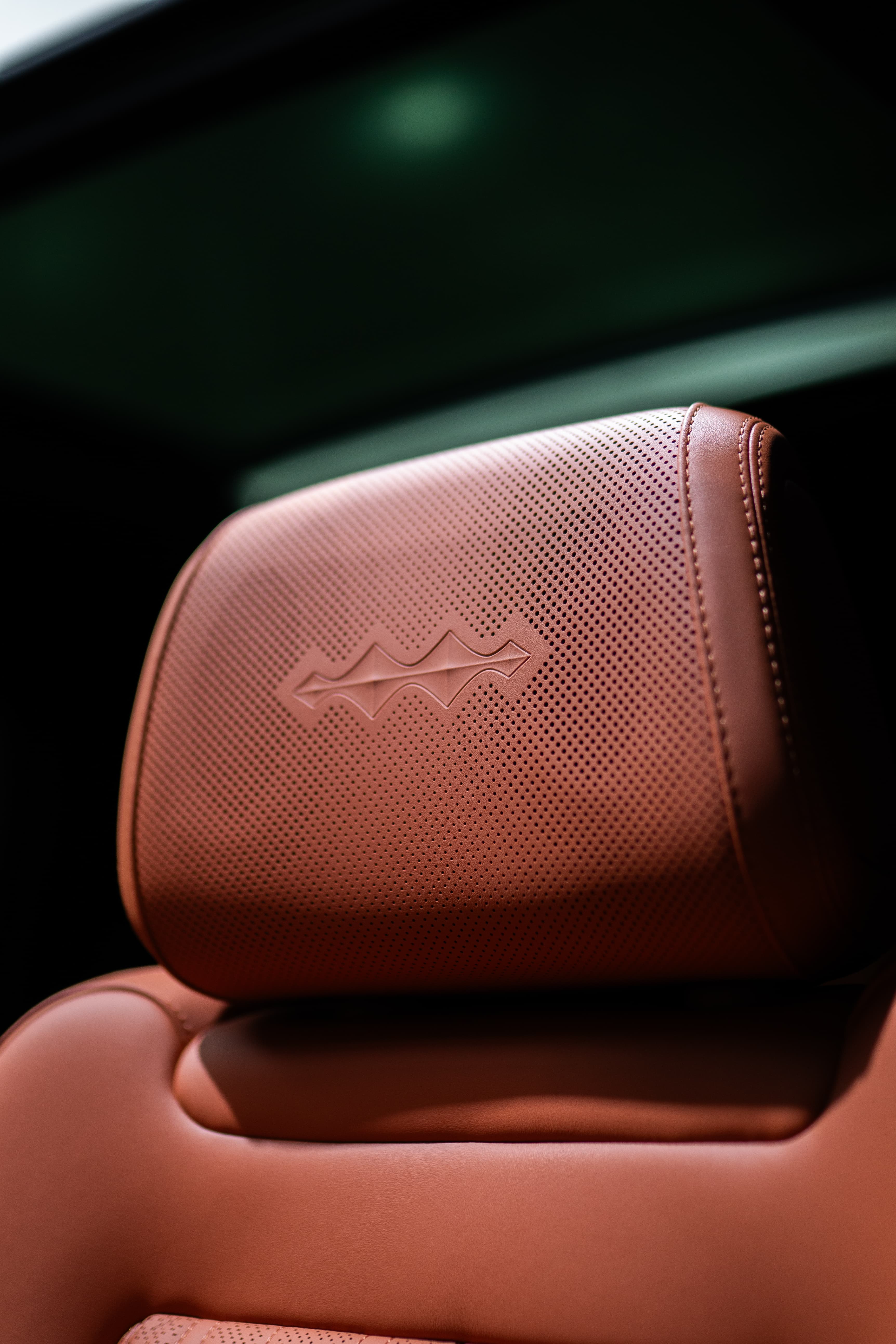Embossed ASV Phantom logo on a luxury vehicle's interior headrest leather